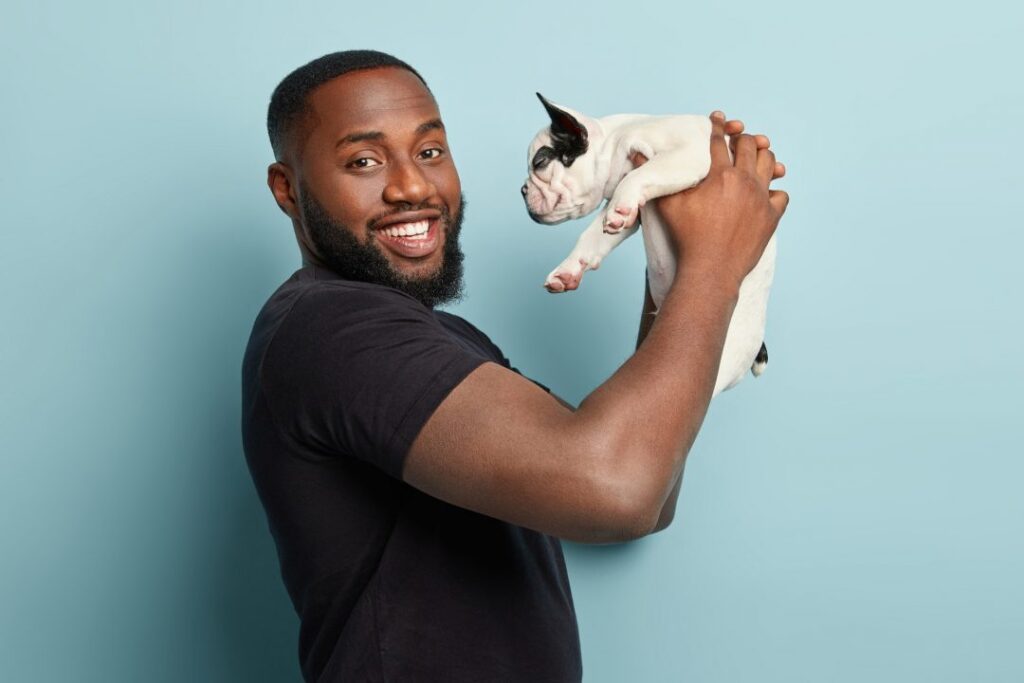 A man happily handing his dog over to a pet caretaker